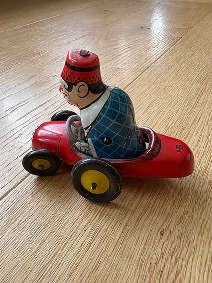 Uppdragbar plåtleksak clown i röd bil Biller