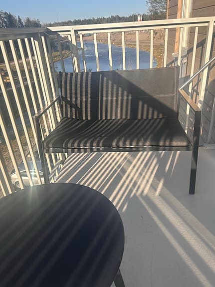 Svart balkongmöbelset med två stolar, soffa och runt bord