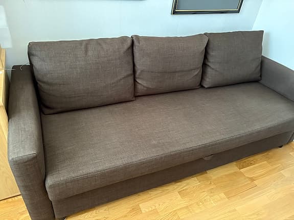 Brun bäddsoffa med tre ryggkuddar