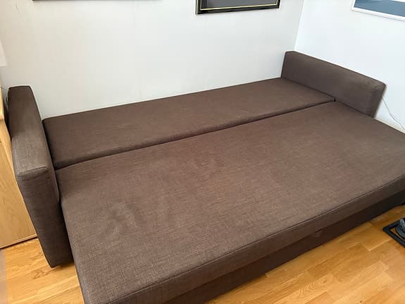Brun bäddsoffa med tre ryggkuddar