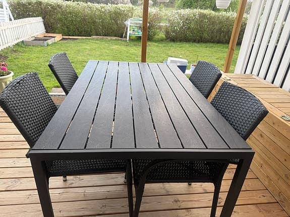 Svart matgrupp utebord med stolar i konstrotting