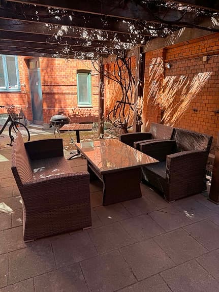 Utegrupp i konstrotting med bord och soffor