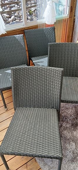 Svarta flätade utestolar i konstrotting