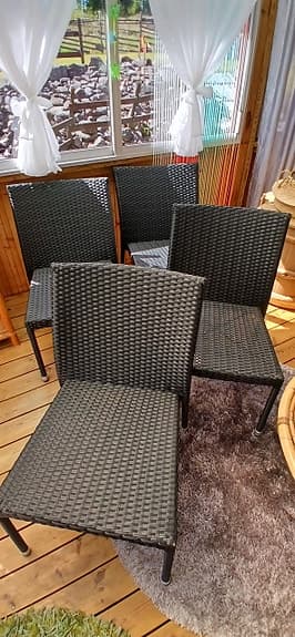 Svarta flätade utestolar i konstrotting