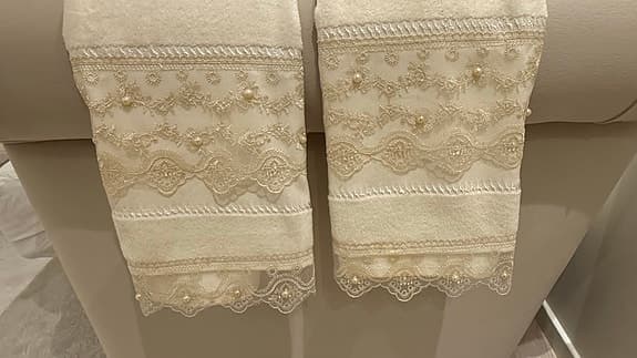 Beige lyxiga handdukar med spets och pärldetaljer