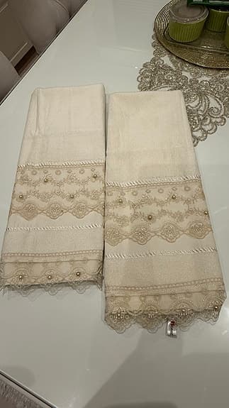 Beige lyxiga handdukar med spets och pärldetaljer