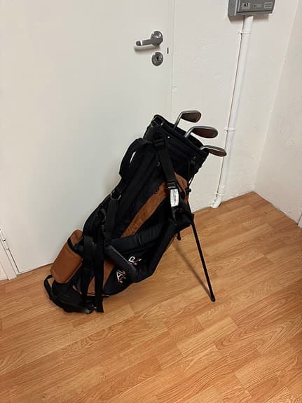 Golfbag med ställ och några klubbor svart/brun