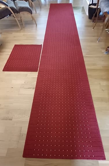 Röd dörrmatta och gångmatta med rutmönster