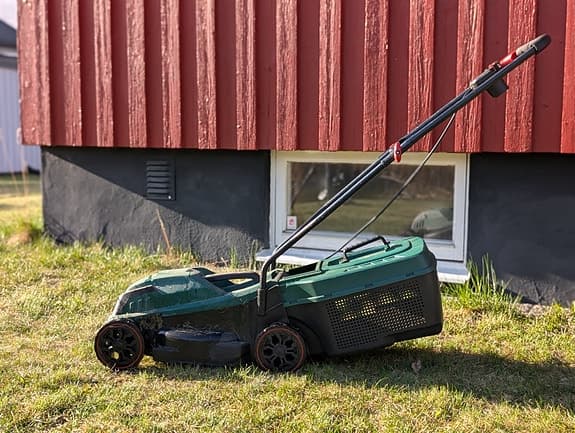 Grön elgräsklippare med uppsamlare