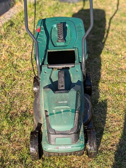 Grön elgräsklippare med uppsamlare