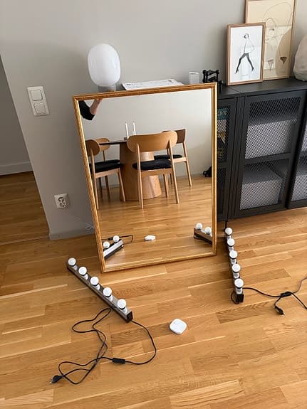 Guldfärgad spegel samt dimbara vägglampor