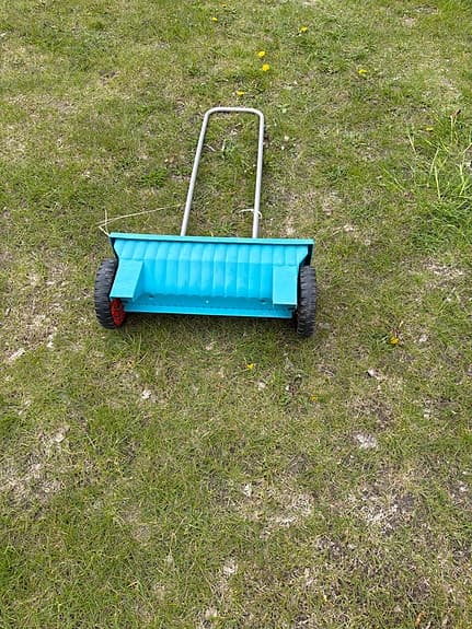 Blå sand- och gödselspridare för gräsmatta