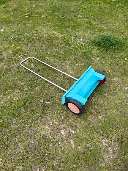 Blå sand- och gödselspridare för gräsmatta