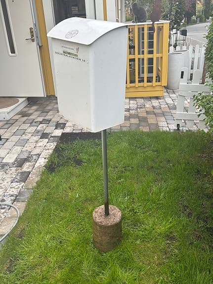 Vit brevlåda på stolpe
