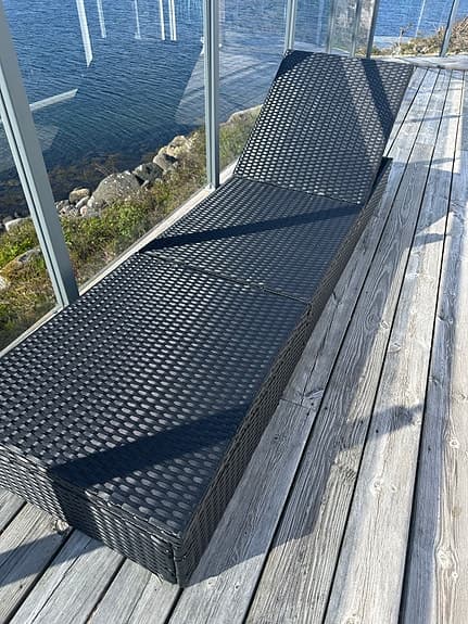 Svart solstol i konstrotting för uteplats