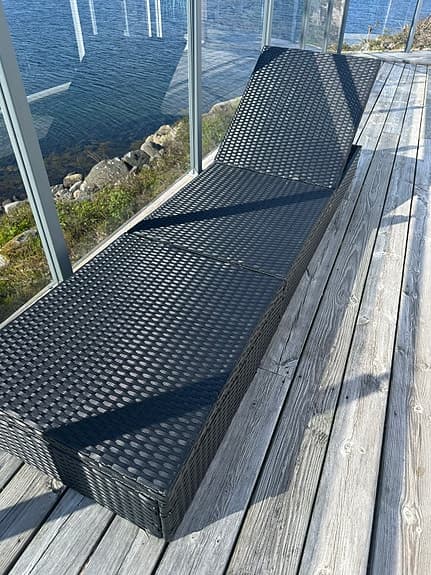 Svart solstol i konstrotting för uteplats