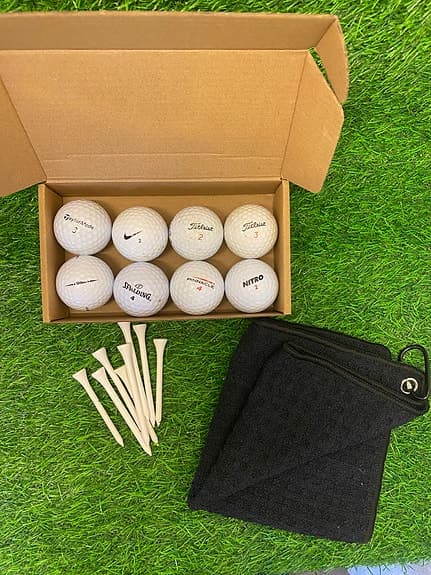 Golfbollar, peggar och golfhandduk