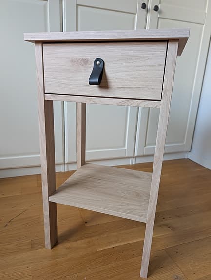 Sängbord i ljus ekdekor med läderhandtag i nyskick