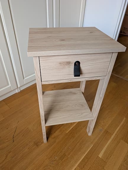 Sängbord i ljus ekdekor med läderhandtag i nyskick