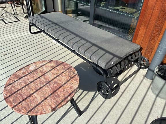 Svart solsäng med grå dyna