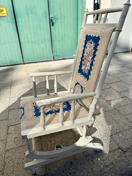 Charmig äldre gungstol i allmogestil med broderad klädsel