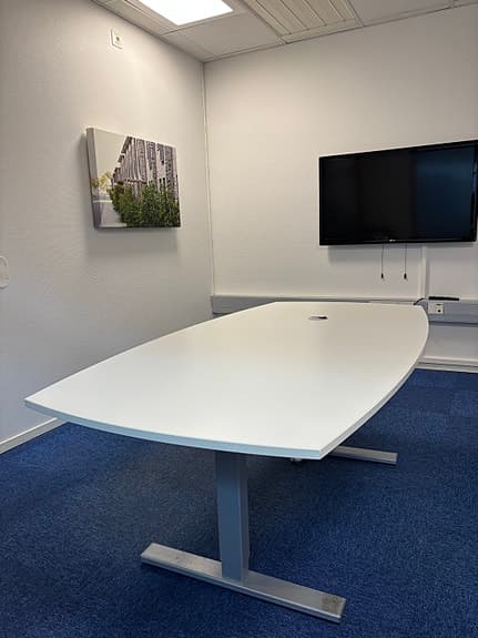 Vitt konferensbord med kabelgenomföring