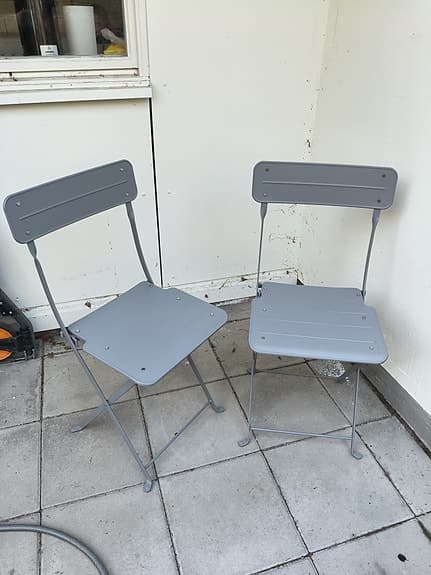 Gråa hopfällbara stolar i metall