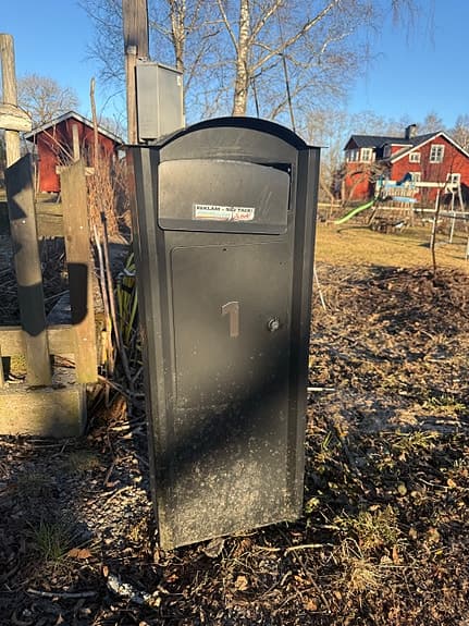 Svart stående postlåda i metall