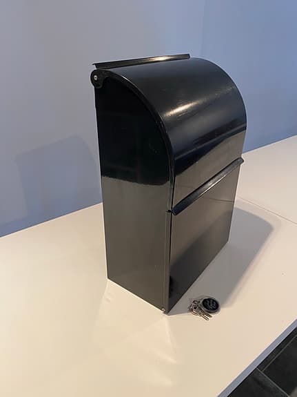 Svart postlåda med lock och lås