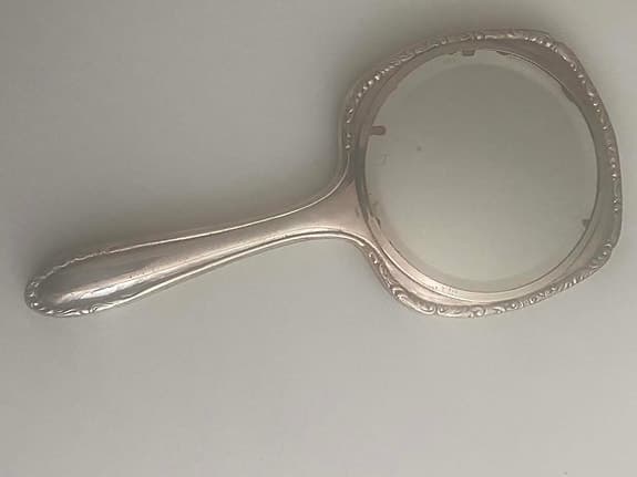 Hand spegel i metall med dekorativ kant, antik