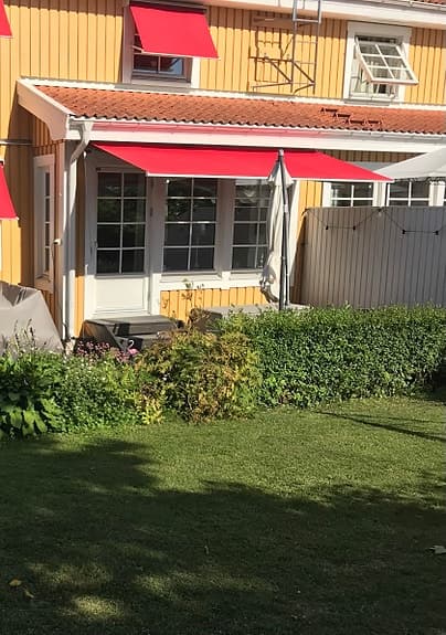 Röd terrassmarkis till uteplats