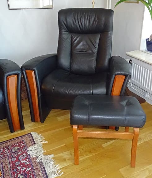 Soffgrupp i svart läder med fåtöljer och soffbord