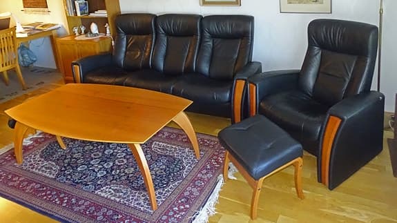 Soffgrupp i svart läder med fåtöljer och soffbord