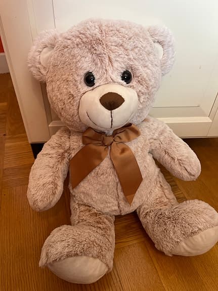 Liten beige nallebjörn med rosett