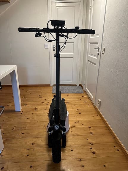 Svart elsparkcykel med fram- och bakljus