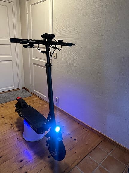 Svart elsparkcykel med fram- och bakljus