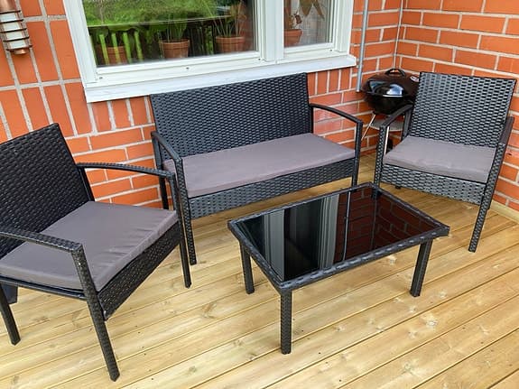 Utegrupp i konstrotting med bord och dynor
