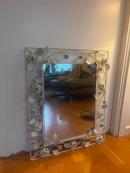 spegel med vit metallram och blommor