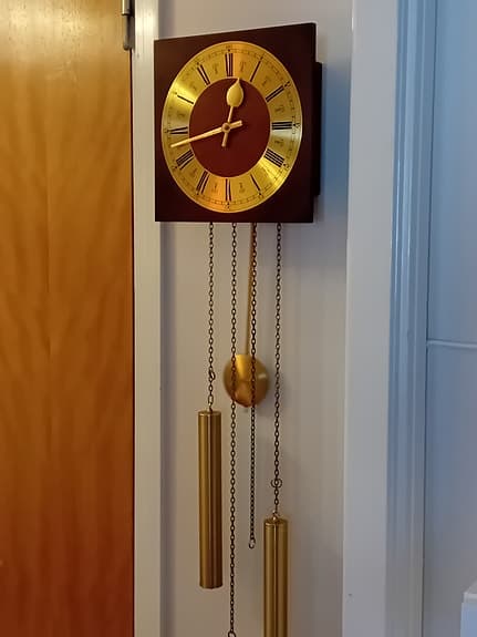 Väggklocka med pendel i guld och trä