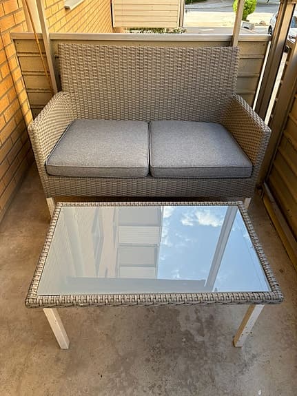 Utegrupp med soffa och glasbord i konstrotting