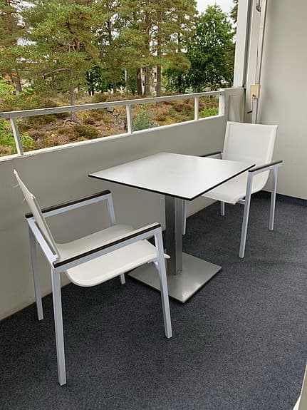 Vit balkonggrupp med bord och 2 stolar