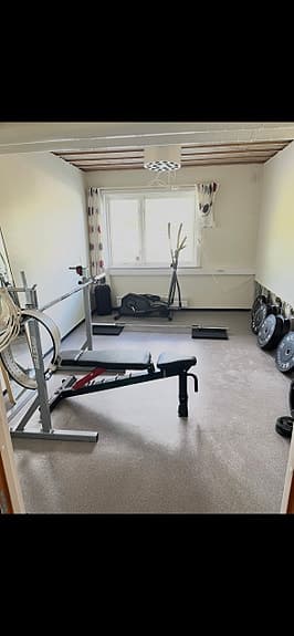 Träningsbänk med skivstångsställning och vikter