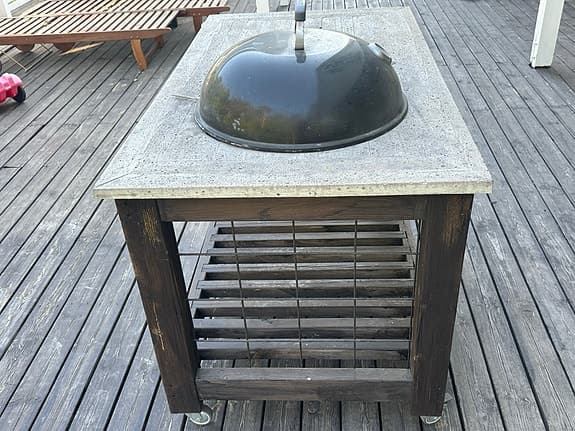 Inbyggd kolgrill i betongbord med förvaringshylla