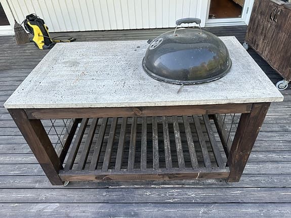 Inbyggd kolgrill i betongbord med förvaringshylla