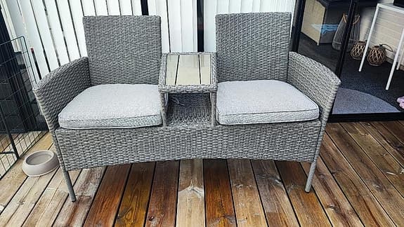 Utebänk i konstrotting med bord och dynor