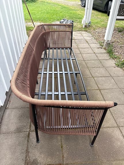 Brun utesoffa med svart metallstomme