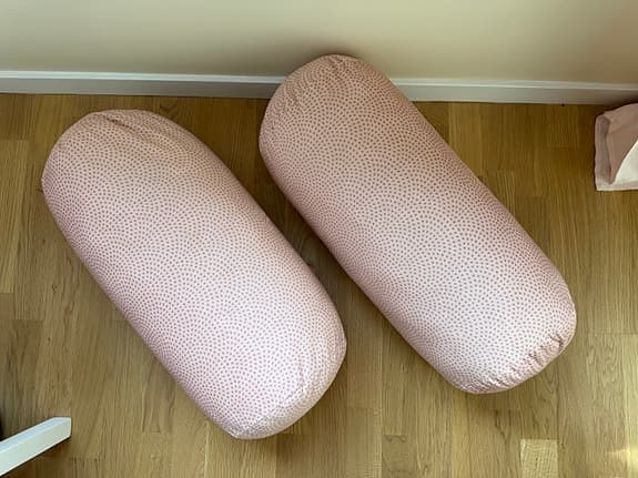 Två rosa cylinderkuddar