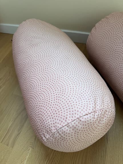 Två rosa cylinderkuddar