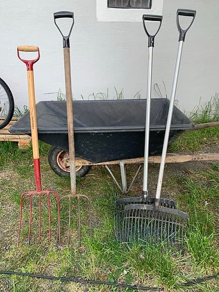 Stor skottkärra och redskap för att mocka ut häst box.