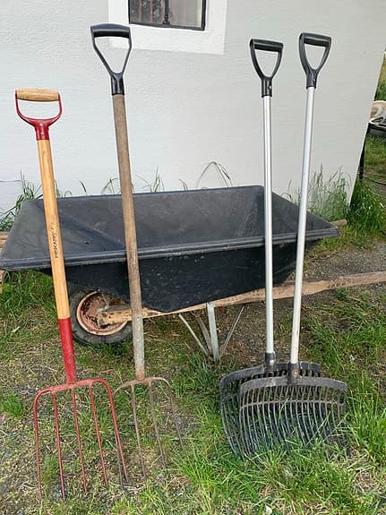 Stor skottkärra och redskap för att mocka ut häst box.